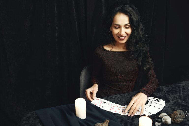 Woman smiling while doing tarot reading with candles and crystals. Perfect for spirituality themes.